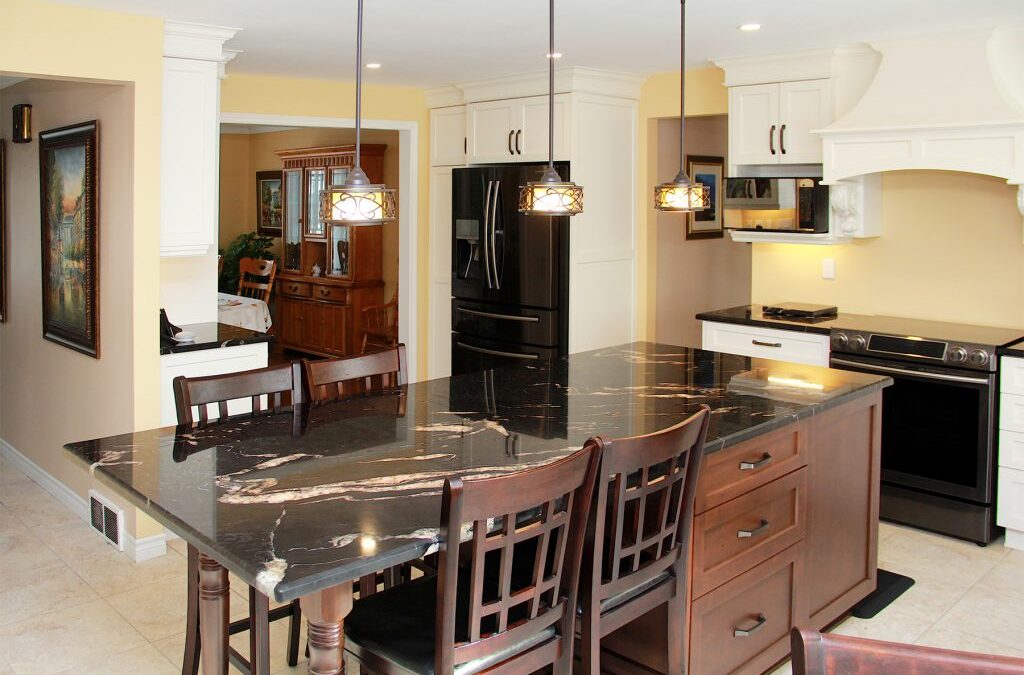 Dark island and countertops create striking contrast with white cabinets and light open space.