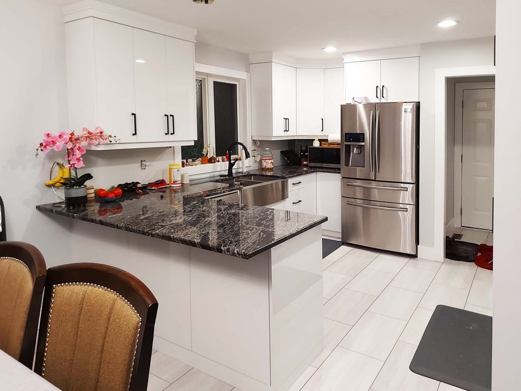 Fridge wall, peninsula and sink in gloss white with plain slab cabinet doors and drawers