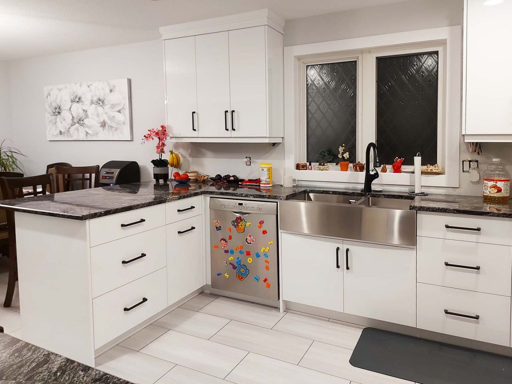 Sink and peninsula in gloss white with plain slab cabinet doors and drawers