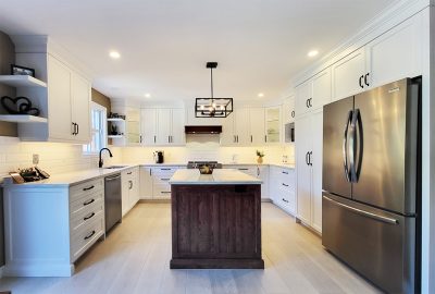 White U-shaped kitchen with dark red oak island and white countertops and backsplash